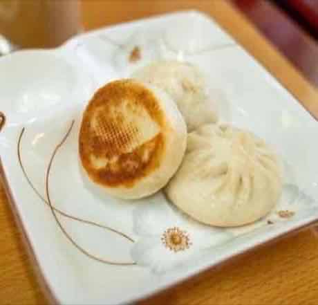 Golden pan-seared pork buns with soft tops and crisp golden bottoms
