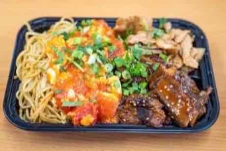 Take-out combo tray with lo mein, tomato and egg, wok-fried chicken and braised ribs