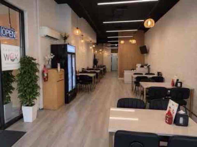 Bright, freshly remodeled Fashion Wok dining room with modern seating and warm pendant lighting
